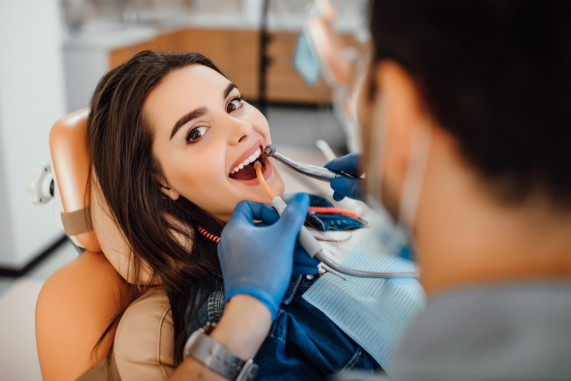 A dentist treating a patient in the surgery chair